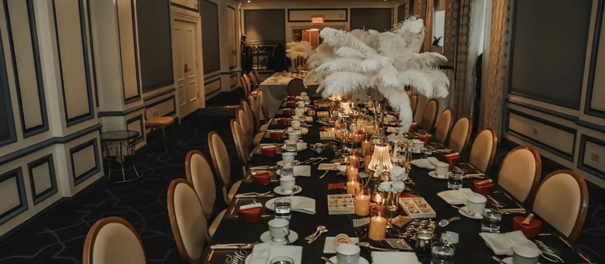 Banquet table with candles and feather centrepieces at a private celebration